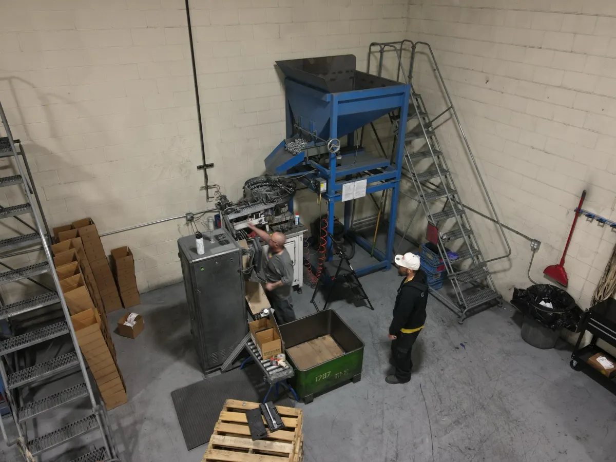 Sort-Tek workers operating automated feeder machine